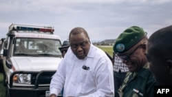 FILE: Former Kenyan president Uhuru Kenyatta (L) talks with military authorities upon his arrival in Goma, eastern Democratic Republic of Congo, on November 15, 2021.