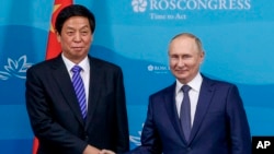 在俄罗斯符拉迪沃斯托克举行的东方经济论坛期间，俄罗斯总统普京（右）和中国全国人大常委会委员长栗战书在会谈前合影留念。（2022年9月7日）
