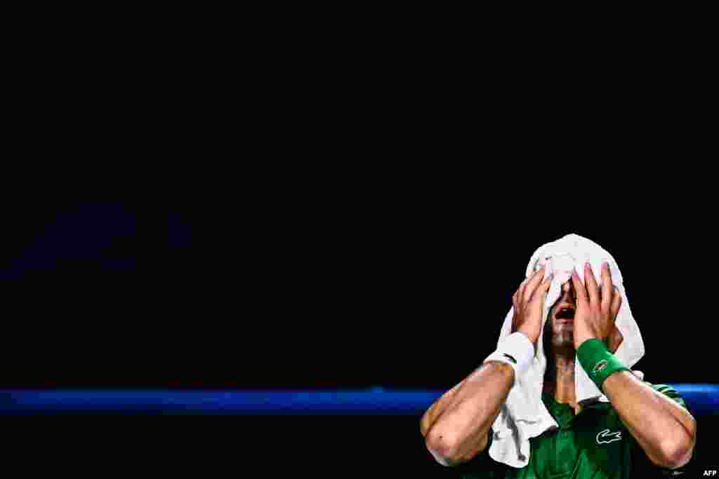 Serbia's Novak Djokovic wipes his face before undergoing a new medical evaluation from a physiotherapist during his round-robin match against Russia's Daniil Medvedev at the ATP Finals tennis tournament in Turin, Italy.