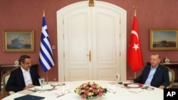 FILE - In this photo provided by the Turkish Presidency, Greek Prime Minister Kyriakos Mitsotakis, left, is seen with Turkish President Recep Tayyip Erdogan during a rare bilateral meeting in Istanbul, Turkey, March 13, 2022.