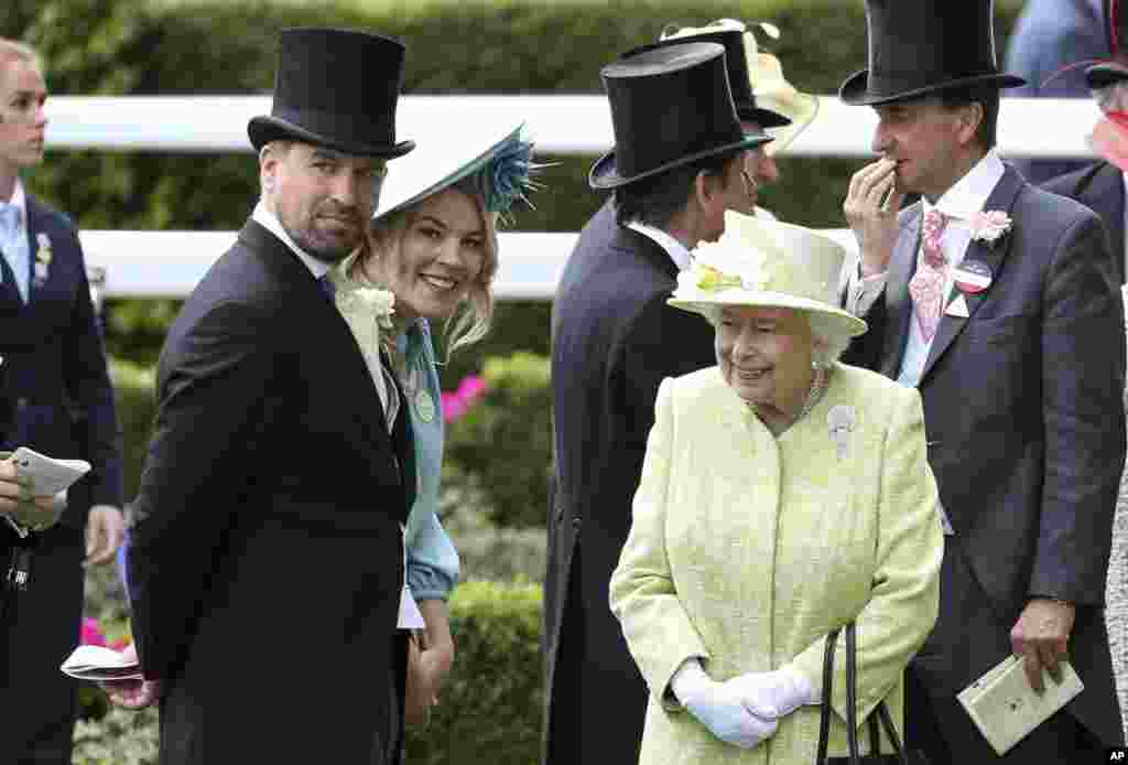 Queen Elizabeth II, right, talks to her grandson Peter Phillips, left, and his wife, Autumn, during day five of Royal Ascot in Ascot, England, June 22, 2019.