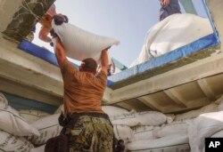 Petugas menginventarisasi urea dan amonium perklorat yang ditemukan pada sebuah dhow yang dicegat di Teluk Oman pada 9 November 2022. (Teknisi Sonar Kelas 1 Kevin Frus/Angkatan Laut AS via AP)