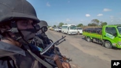 In this image made from video, Rwandan police patrol a road in Palma, Cabo Delgado province, Mozambique, Aug. 15, 2021. A new offensive by Mozambique's Islamic extremist rebels in Cabo Delgado has increased the number of displaced by 80,000.