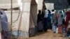 FILE - People line up at a makeshift health clinic treating patients suffering from meningitis, in Lazaret, near Niamey, Niger, April 23, 2015.