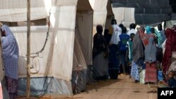 FILE - People line up at a makeshift health clinic treating patients suffering from meningitis, in Lazaret, near Niamey, Niger, April 23, 2015.