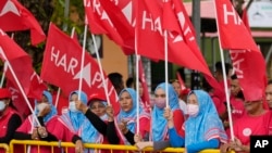 Supporters of the Pakatan Harapan alliance wave flags on election nomination day outside a nomination center in Langkawi Island, Malaysia, Nov. 5, 2022.