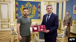 El presidente ucraniano Volodymyr Zelensky (izq.) otorga la Orden al Mérito, primer grado, al CEO de Baykar Makina, Haluk Bayraktar de Turquía durante su reunión en Kiev, Ucrania, el 9 de septiembre de 2022.