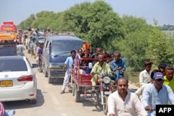 Internally displaced flood-affected residents along with their belongings arrive from the flooded areas to safer grounds after heavy monsoon rains in Sehwan of Jamshoro district, Sindh province, Pakistan, Sept. 8, 2022.