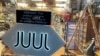FILE - A Juul electronic cigarette sign hangs in the front window of a bodega convenience store in New York City on June 25, 2022. 