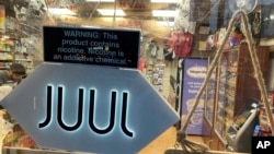 FILE - A Juul electronic cigarette sign hangs in the front window of a bodega convenience store in New York City on June 25, 2022. 