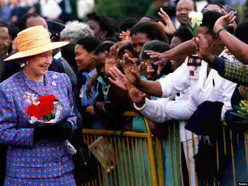 Queen Elizabeth II is greeted by residents outside Baragwanath Hospital in Soweto township southwest of Johannesburg, South Africa, March 23, 1995. REUTERS/Stringer/File Photo