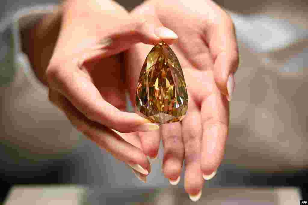 A representative from Sotheby&#39;s Hong Kong holds up the Golden Canary diamond in Hong Kong.