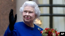 FILE - In this Tuesday, Dec. 18, 2012 file photo, Britain's Queen Elizabeth II looks up and waves to members of staff of The Foreign and Commonwealth Office as she ends an official visit.