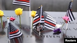 Flags and flowers are placed at the 9/11 Memorial and Museum during a ceremony marking the 21st anniversary of the September 11, 2001 attacks on the World Trade Center, in the Manhattan borough of New York City, Sept. 11, 2022.