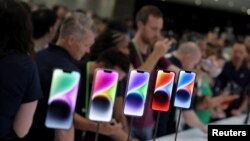 Guests look at the new iPhone 14 at an Apple event at its headquarters in Cupertino, Calif., Sept. 7, 2022.