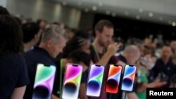 Para tamu undangan tampak mengamati iPhone 14 dalam acara peluncuran produk baru Apple di markas mereka di Cupertino, California, pada 7 September 2022. (Foto: Reuters/Carlos Barria)