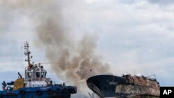 Un remolcador combate un incendio en el pesquero venezolano Taurus I en la ciudad portuaria de Buenaventura, en la costa pacífica de Colombia, el 6 de septiembre de 2022.