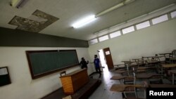 David Sosa (R), presidente de la federación de estudiantes de la Universidad Central de Venezuela (UCV), habla con un compañero de estudios en un aula de la Facultad de Humanidades y Educación, en Caracas, Venezuela, el 29 de septiembre de 2020.