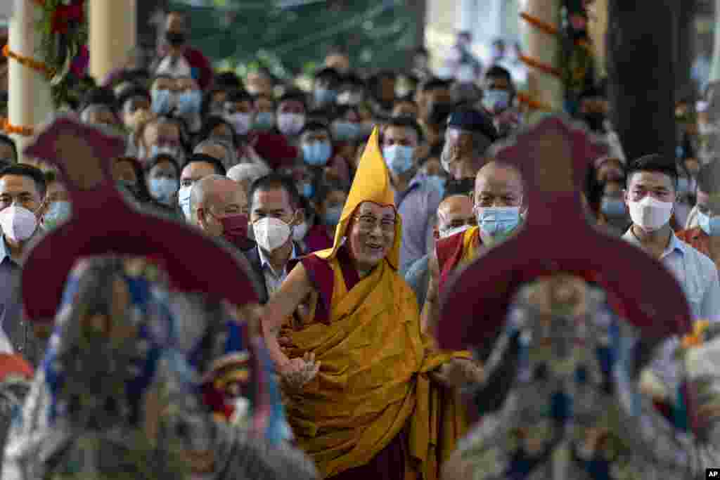 Tibetan spiritual leader the Dalai Lama, center, in a yellow ceremonial hat, watches a welcome dance performed by Tibetan artists, as he arrives at the Tsuglagkhang Temple in Dharmsala, India.