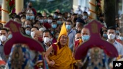 Tibetan spiritual leader the Dalai Lama, center, in a yellow ceremonial hat, watches a welcome dance performed by Tibetan artists, as he arrives at the Tsuglagkhang Temple in Dharmsala, India. (AP Photo/Ashwini Bhatia)