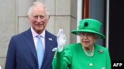 Le 5 juin 2022, la reine Elizabeth II et prince Charles salue le public alors qu'elle apparaît sur le balcon du palais de Buckingham à la fin du Platinum Pageant à Londres.