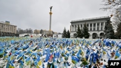 This Nov. 17, 2022, photo shows Ukrainian flags set at Independence Square in Kyiv, symbolizing the deaths of Ukrainian soldiers in the conflict, covered with snow after the first snow falls of the season.