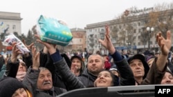 Kherson residents grab items from an aid supply distribution in the center of the city on Nov. 17, 2022.