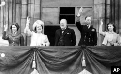 FILE - In this May 8, 1945 file photo Britain's Prime Minister Winston Churchill, center, joins the Royal family, from left, Princess Elizabeth, Queen Elizabeth, King George VI, and Princess Margaret, on the balcony of Buckingham Palace, London, England,