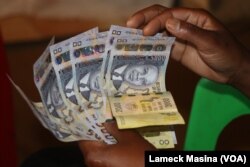 FILE - A trader counts Malawi currency, the Kwacha, in Blantyre, Malawi. (Lameck Masina/VOA)