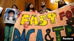 DACA recipients hold up a sign after an event by Democrats calling for congressional Republicans to bring forward immigration legislation on Capitol Hill in Washington, Sept. 6, 2017.