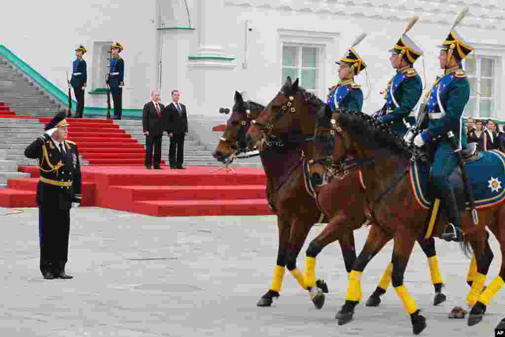 Presiden Rusia Vladimir Putin (kiri) dan mantan Presiden Dmitry Medvedev menyaksikan parade pengawal kehormatan Kremlin di Lapangan Katedral setelah upacara pelantikan.