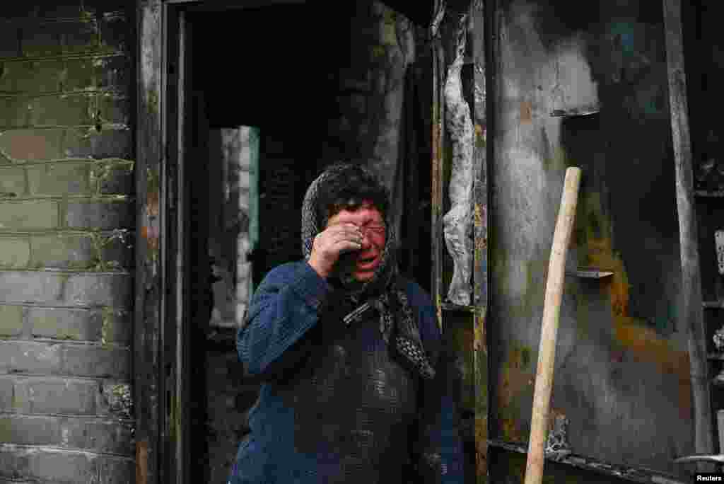 Resident Natalia reacts next to her house heavily damaged during a Russian military strike in the village of Hirske, amid Russia&#39;s attack on Ukraine, near the Russian border in Chernihiv region.