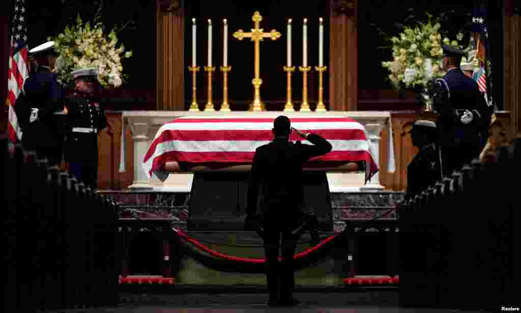 People pay their respects as the flag-draped casket of former President George H.W. Bush lies in repose at St. Martin's Episcopal Church in Houston, Dec. 5, 2018.