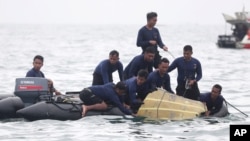 Indonesian Navy divers pull out a part of an airplane out of the water during a search operation for the Sriwijaya Air passenger jet that crashed into the sea near Jakarta, Indonesia, Jan. 10, 2021.