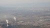 Asap dan uap tampak mengepul dari menara yang berada di area pembangkit listrik tenaga batu bara di Xinjiang, pada 21 April 2021. (Foto: AP/Mark Schiefelbein)