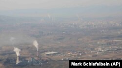 Asap dan uap tampak mengepul dari menara yang berada di area pembangkit listrik tenaga batu bara di Xinjiang, pada 21 April 2021. (Foto: AP/Mark Schiefelbein)