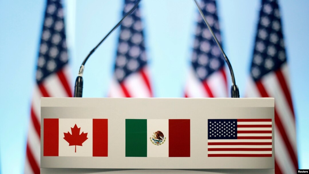 FILE - The flags of Canada, Mexico and the U.S. are seen on a lectern before a joint news conference on the closing of the seventh round of NAFTA talks in Mexico City, Mexico, March 5, 2018. 