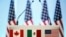 FILE - The flags of Canada, Mexico and the U.S. are seen on a lectern before a joint news conference on the closing of the seventh round of NAFTA talks in Mexico City, Mexico, March 5, 2018. U.S. President Donald is now looking to pursue separate deals with the two neighbors, a White House adviser said.