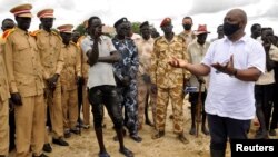 FILE - Alain Noudehou, UN Humanitarian Coordinator in South Sudan, addresses members of his delegation as they visit civilians displaced by flood water caused by broken dykes on the Nile river, in Duk padiet county of Jonglei State, in South Sudan Sept. 2