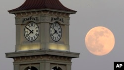 FILE - The moon rises behind the Home Place clock tower in Prattville, Ala., Saturday, June 22, 2013. (AP Photo/Dave Martin, File)