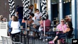 FILE - Customers sit outside a cafe at Bondi Beach in Sydney, Australia, Jan. 8, 2022. 