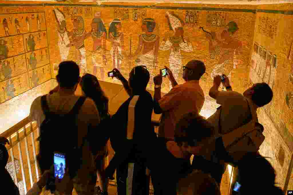 Visitors film inside the tomb of King Tutankhamun in the Valley of the Kings in Luxor, Egypt. Egypt celebrates the 100-year anniversary of the discovery of Tutankhamun&#39;s tomb by British archaeologist Howard Carter and his team.