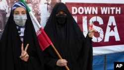 Iranian women flash victory signs during an annual rally in front of the former U.S. Embassy in Tehran, Iran, Nov. 4, 2022.