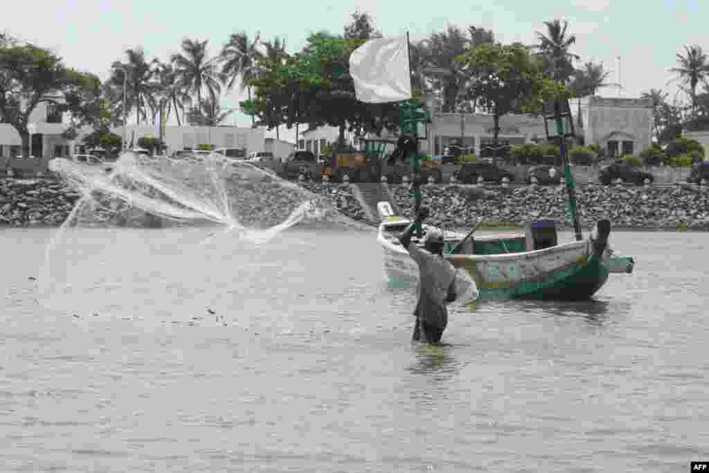 Fisherman throws his net in the lagoon in Aneho, Togo, on November 3, 2022.&nbsp;