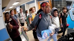 Students at the Washington Junior High School leaving classes for the day, use the unlocking mechanism to open the bags their cell phone were sealed in during the school day, Oct. 27, 2022, in Washington, Pa.