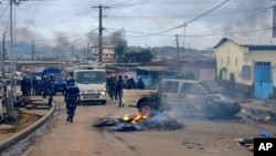 La police de prend le contrôle d'une rue bloquée par une barricade en feu, dans le quartier Cocotiers de Libreville, au Gabon, 15 août 2012 (Archives). (AP Photo / Joel Bouopda Tatou)