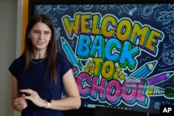 Yana Kudina, a Ukrainian teacher who gives Polish language lessons to Ukrainian refugee students, greets her class on the first day of school in Warsaw, Sept. 2, 2024