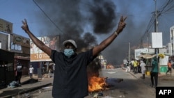 An opposition supporter reacts in front of a burning barricade during demonstrations called by the opposition parties in Dakar on Feb. 4, 2024. 