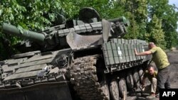 Ukrajinski vojnici popravljaju tenk na putu u Donjeckoj oblasti 30. juna 2023. godine 
