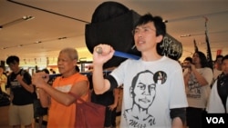 現年78歳的香港社運老將 古思堯(左)，2013年5月26日參與前學民思潮平反六四遊行，與社民連前主席吳文遠（右），抬著道具棺材遊行經過一間百貨公司。(美國之音/湯惠芸)
